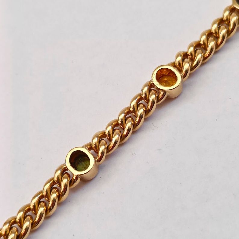 Gold chain bracelet with embedded gemstones 